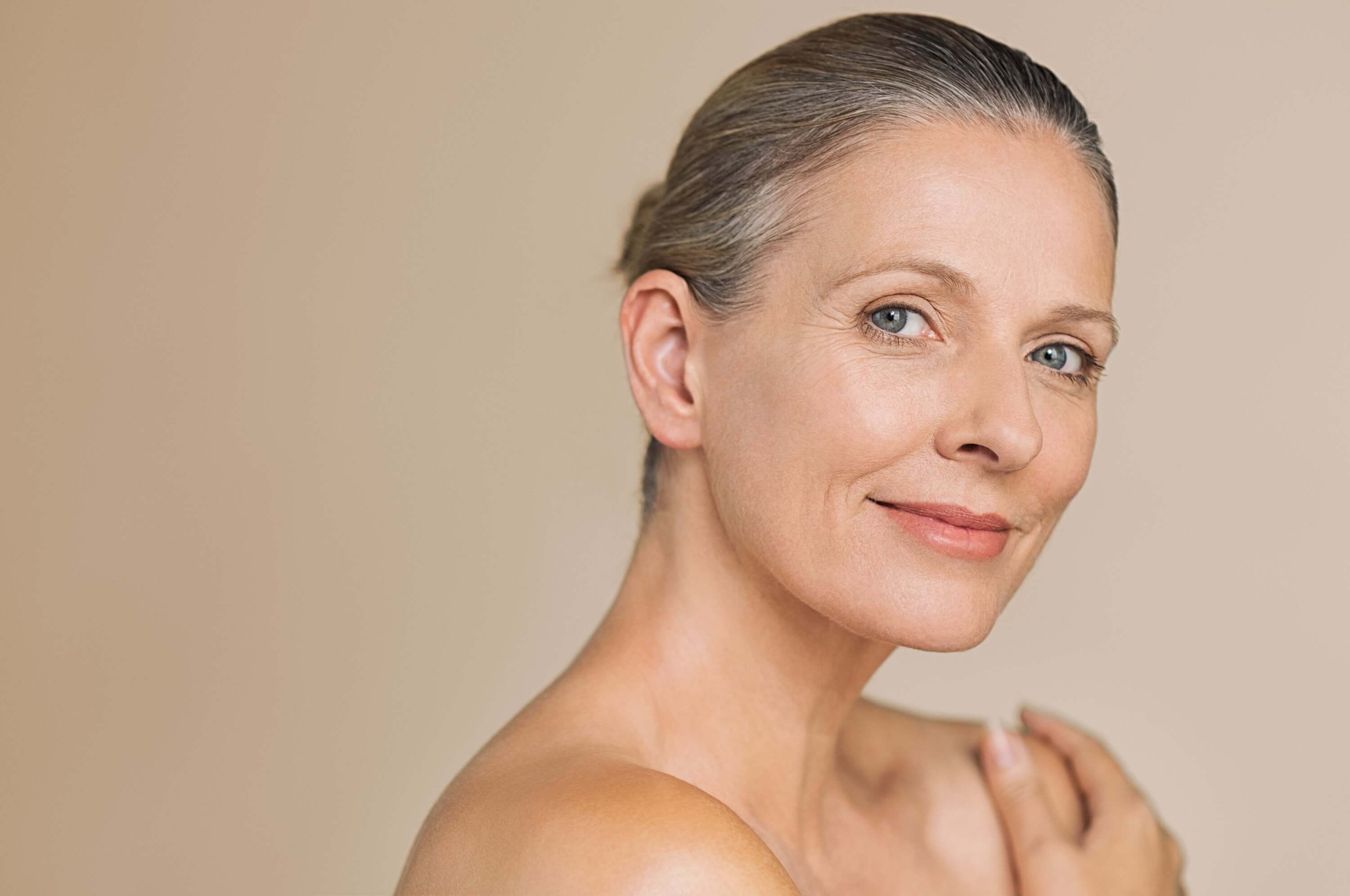 Confident mature woman with healthy glowing skin, representing timeless beauty and skincare results