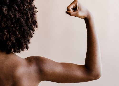 Photo of a woman flexing her arm months after an arm lift