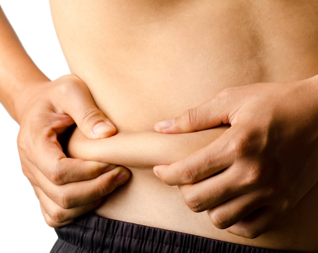 Photo of a man punching the fat on the side of his body