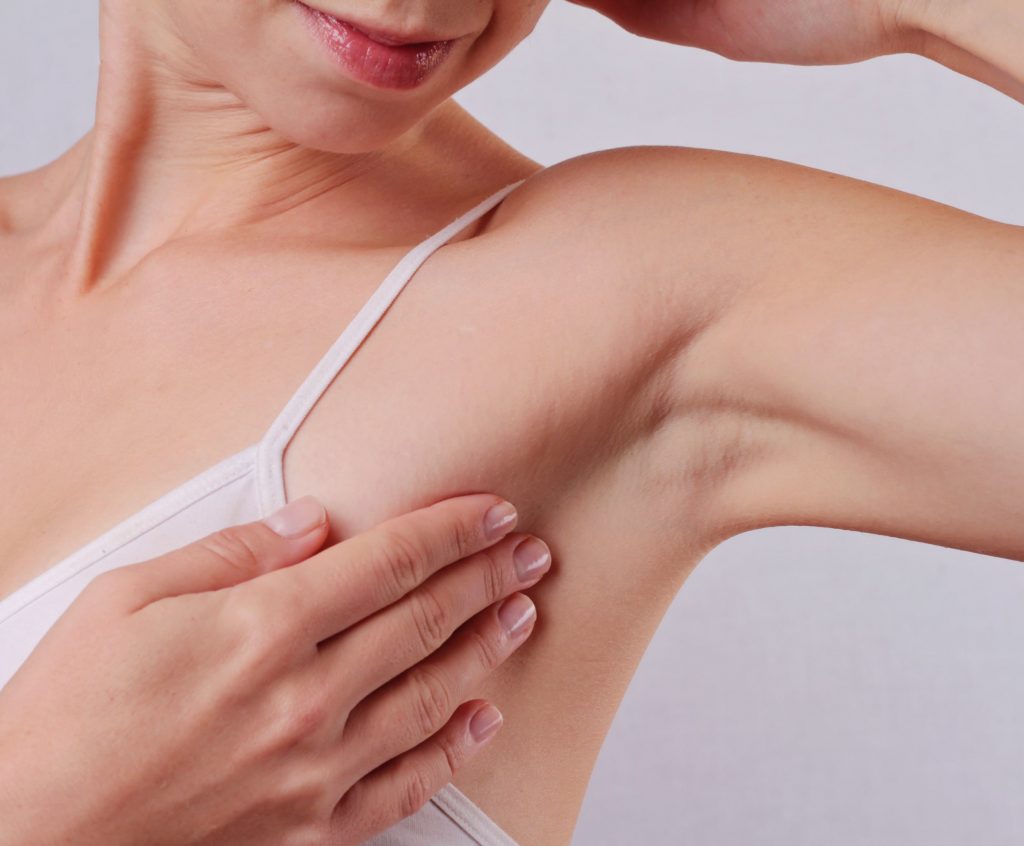 Photo of a woman checking her hairless armpit