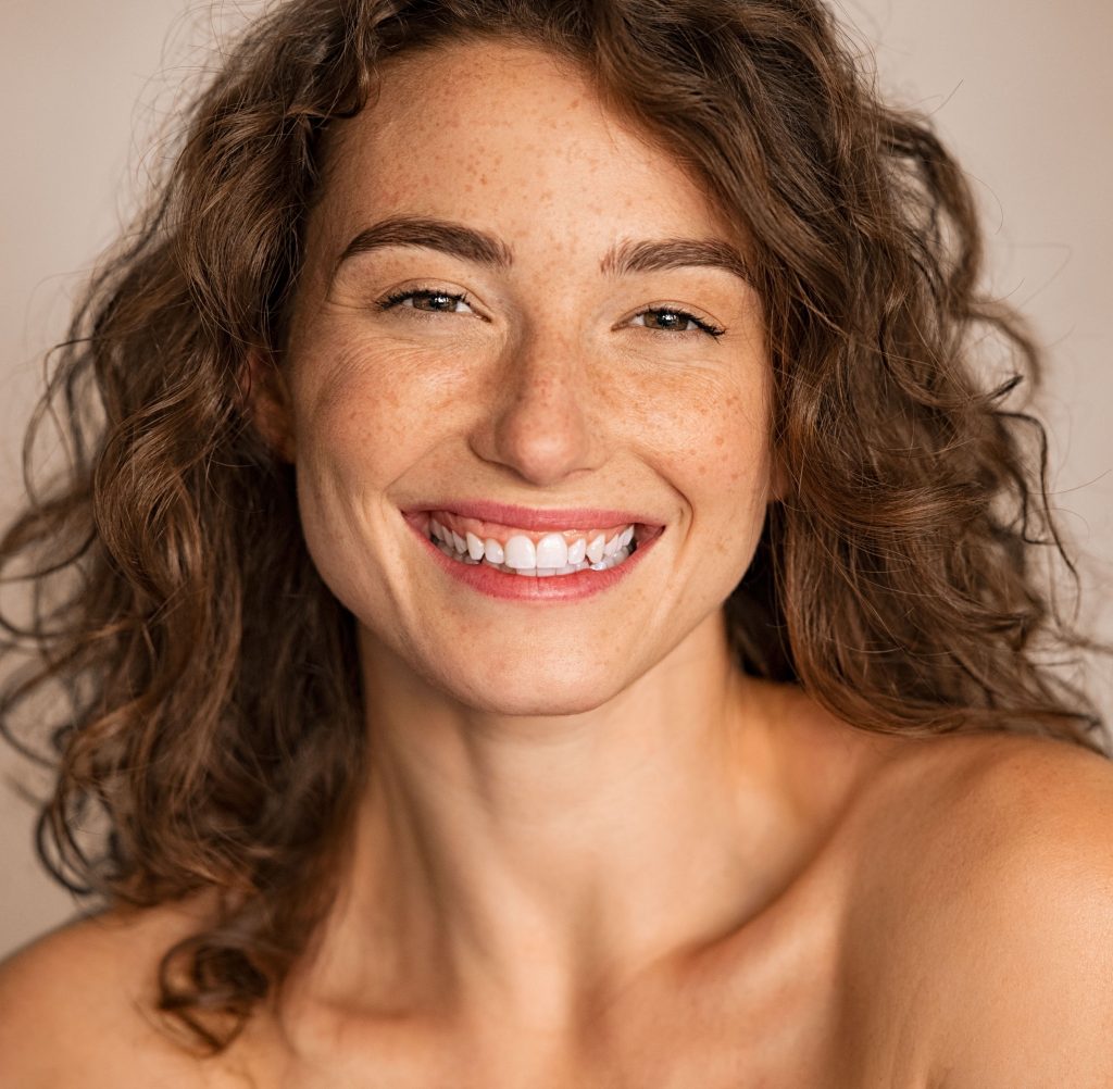 Photo of a smiling woman with freckles on her face