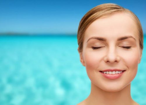 Photo of a woman at the beach closing her eyes