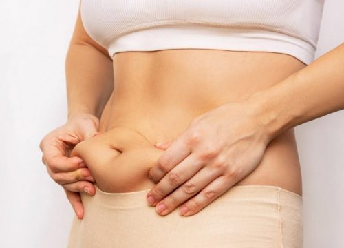 Photo of a woman pinching her belly fat