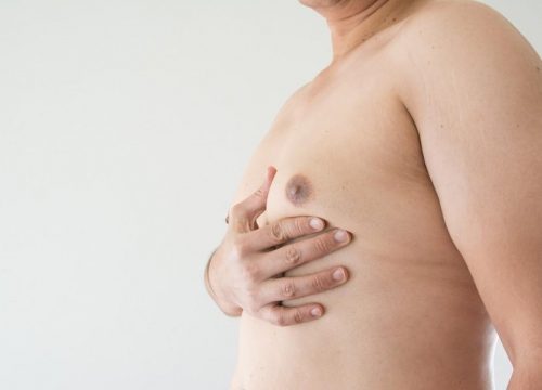 Photo of a man touching his man boobs